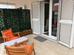a patio with chairs and a table and a green wall at Stella in Šibenik
