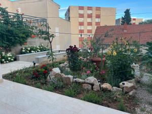 a garden with flowers and rocks in front of a building at Stella in Šibenik