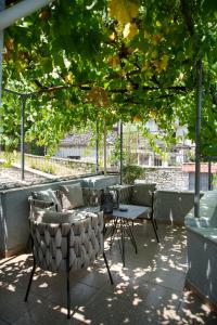 a patio with chairs and a table under a tree at Old Bazaar Balcony Villa in Gjirokastër