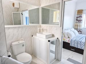 a bathroom with a toilet and a sink and a bed at Appartement moderne avec balcon in Lomé +27 photos