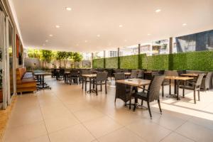 a restaurant with tables and chairs in a building at Hawaii Suite Beach Hotel in Alanya