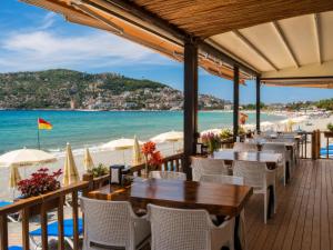 a restaurant on the beach with tables and chairs at Hawaii Suite Beach Hotel in Alanya