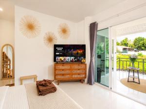 a bedroom with a bed and a tv and a balcony at Boho House - 2mn Srithanu - King Bed - 4K SmartTV in Hinkong