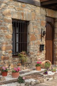 a stone building with potted plants in front of a window at Caserio Urikosolo in Bilbao +61 photos