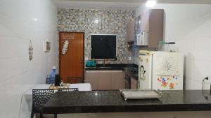 a kitchen with a counter top and a refrigerator at Casa com varanda, garagem e cozinha completa in Formosa
