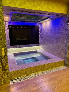 a jacuzzi tub in a room with purple lights at Israel Ori Hotel in Yerevan
