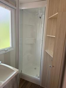 a shower with a glass door in a bathroom at Camping Le Capdeville in Carcans +16 photos