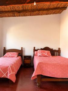 two beds sitting next to each other in a bedroom at Cabañas tilcara sarahuayco in Tilcara
