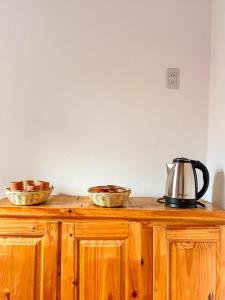 a wooden cabinet with three bowls and a tea kettle on it at Cabañas tilcara sarahuayco in Tilcara