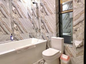 a bathroom with a toilet and a tub and a sink at Appart Hotel Les orchidees in Cotonou +51 photos