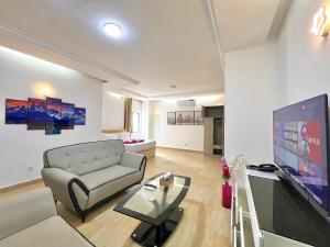 a living room with a couch and a flat screen tv at Appart Hotel Les orchidees in Cotonou