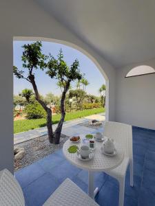 a table and chairs in a room with a tree at Villaggio Marco Polo in Santa Domenica