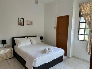 a bedroom with a bed with white sheets and a window at Casa Sara in Nilai +6 photos