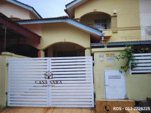 a house with a white garage gate in front of it at Casa Sara in Nilai