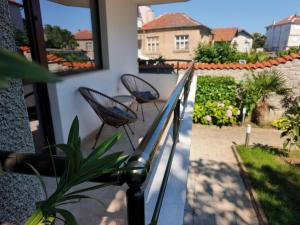 a balcony with two chairs and a view of a yard at Yanevi Apartments in Chernomorets +35 photos