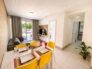 a living room with a table and yellow chairs at Apto. Palm Beach, 300M Beach Park in Aquiraz