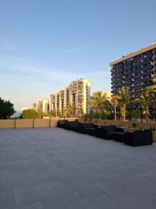a parking lot with chairs and buildings in the background at Costa Royal Resort in Villajoyosa