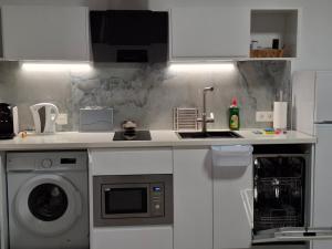 a kitchen with a sink and a washing machine at Costa Royal Resort in Villajoyosa