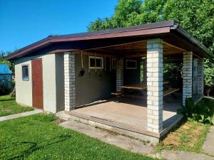 a smallshed with a wooden deck in a yard at Lind Guest House in Haapsalu +5 photos