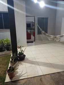 a living room with a hammock and potted plants at Casa com varanda, garagem e cozinha completa in Formosa