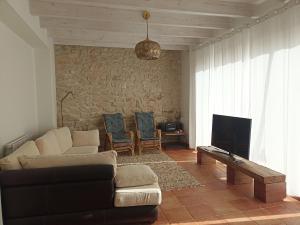 a living room with a couch and a tv at casa LHort in Benisili
