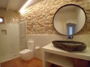 a bathroom with a sink and a mirror and a toilet at casa LHort in Benisili +3 photos