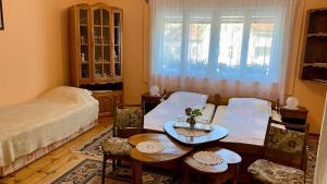 a living room with a bed and a table and chairs at Golyafeszek Vendeghaz in Sîncraiu