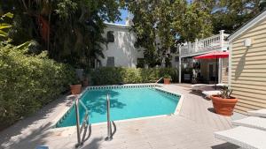 a swimming pool in front of a house at The Independent Inn in Key West