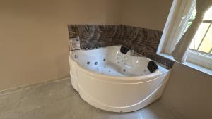 a white bath tub in a bathroom with a window at Romantic Suite Genova in Genoa
