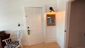 a hallway with a white door and a chair at The Independent Inn in Key West