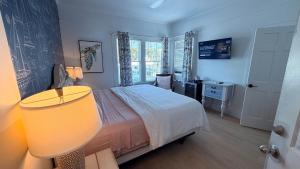 a bedroom with a bed and a table and a lamp at The Independent Inn in Key West