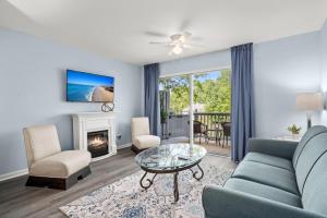 a living room with a couch and a fireplace at Tranquil Condo with Pond View in Charleston