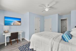 a bedroom with a bed and a desk and a ceiling fan at Tranquil Condo with Pond View in Charleston +28 photos