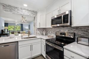 a kitchen with white cabinets and a stove top oven at Tranquil Condo with Pond View in Charleston