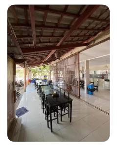 a dining room with tables and chairs in a house at Pousada do Gil in Iguatu