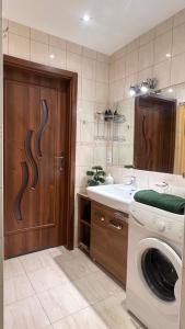 a bathroom with a washing machine and a sink at Przystań przy Krzywej in Dziwnów +17 photos