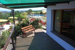 a deck with a bench and a swimming pool at cabañas aleli in Embalse