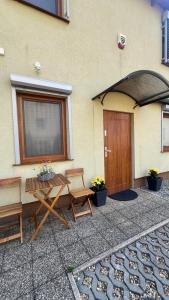 a patio with a table and two chairs next to a building at Przystań przy Krzywej in Dziwnów