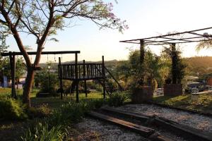 a swing set in a park with a tree at cabañas aleli in Embalse
