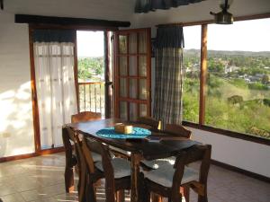 a dining room with a table and chairs and windows at cabañas aleli in Embalse