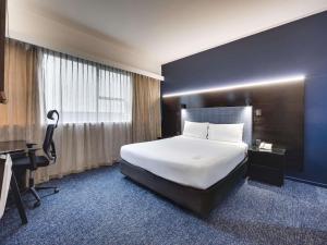 a hotel room with a large bed and a desk at Mercure Wellington Abel Tasman in Wellington +54 photos