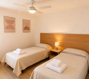 a room with two beds with towels on them at Casa María in Vinarós