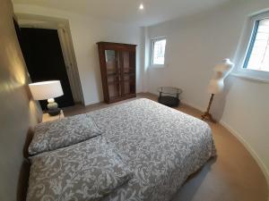 a bedroom with a bed and two lamps and a window at loft with a garage feel in Périers +7 photos
