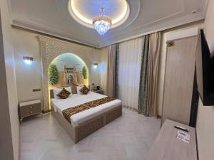a bedroom with a bed and a chandelier at Turon Khiva in Khiva +35 photos