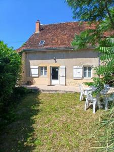 a house with a table and chairs in front of it at La Source de Romay 2 pers 5 min Paray in Volesvres