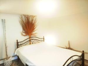 a bedroom with a white bed and a plant on the wall at Volcanic Stone Cottage Sea View & Yard in Kipséli