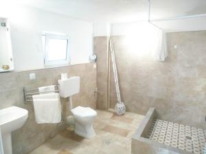a bathroom with a toilet and a sink at Volcanic Stone Cottage Sea View & Yard in Kipséli +14 photos