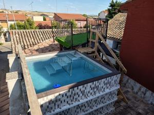 a swimming pool with a table and a bench at Casa rural khaleesi in El Carpio de Tajo