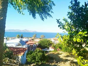 a view from the garden of a house overlooking the ocean at Volcanic Stone Cottage Sea View & Yard in Kipséli