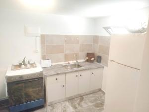 a kitchen with a sink and a stove and a refrigerator at Volcanic Stone Cottage Sea View & Yard in Kipséli